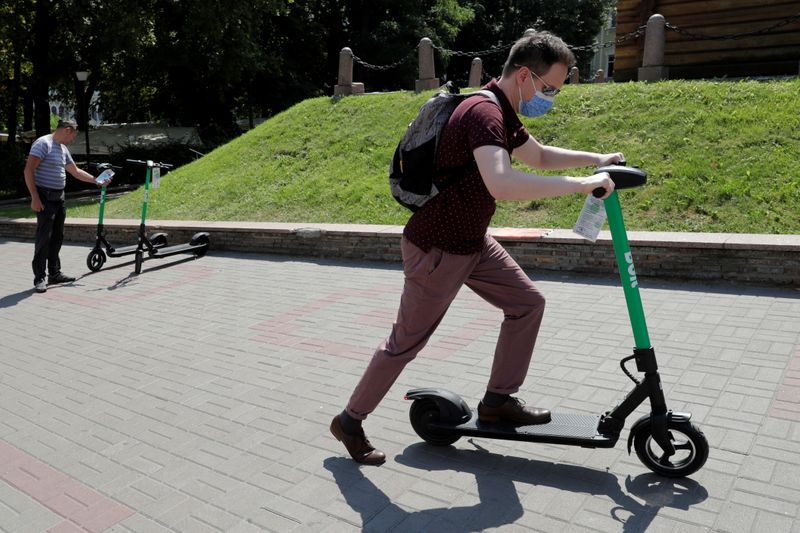 FILE PHOTO: A man uses an e-scooter from provider Bolt