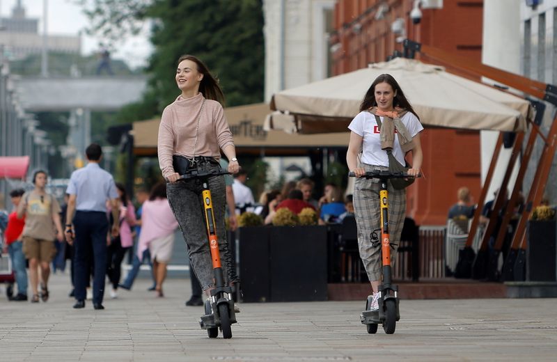 People ride electric scooters in Moscow
