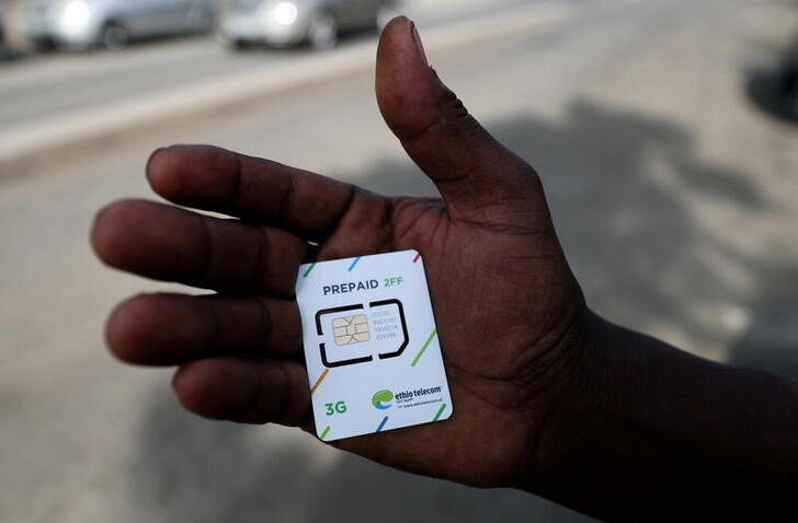 FILE PHOTO: A customer holds a 3G prepaid sim card