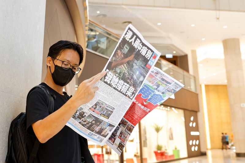 An Apple Daily supporter reads the final edition of the