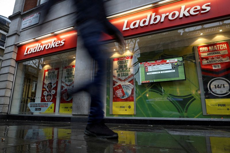 FILE PHOTO: A pedestrian walks past a branch of Ladbrokes