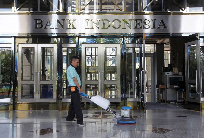 A worker cleans near the front entrance of the Bank