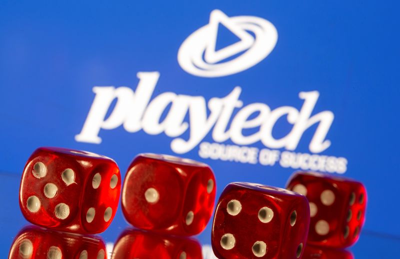 Gambling cubes are seen in front of displayed Playtech logo