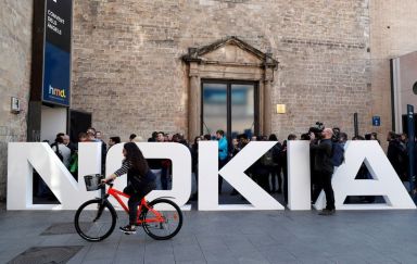 FILE PHOTO: A cyclist rides past a Nokia logo