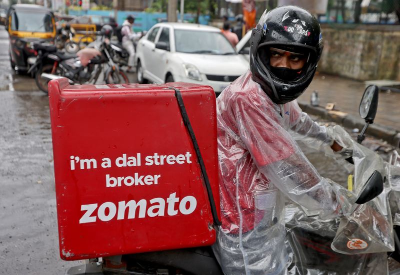 FILE PHOTO: A delivery worker of Zomato leaves to pick
