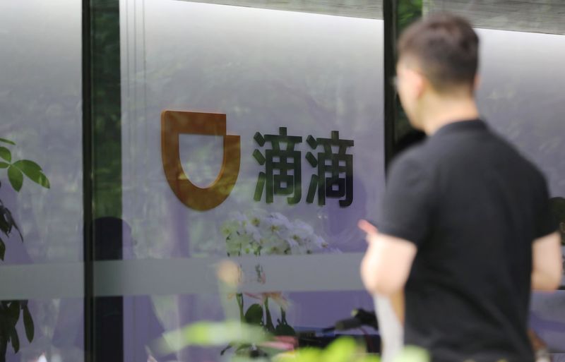 Man walks past the headquarters building of Chinese ride-hailing service