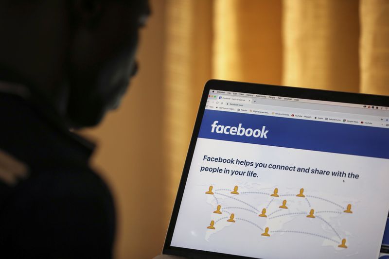 Man opens the Facebook page on his computer in Abuja