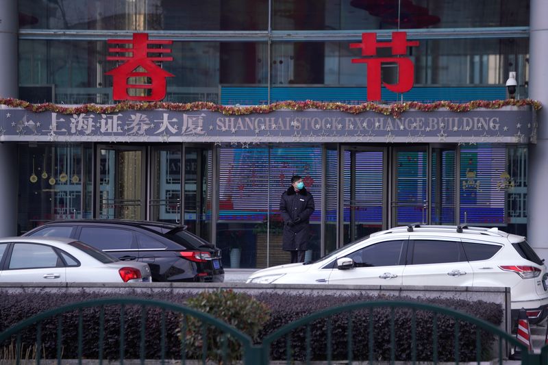 A security guard stands at the Shanghai Stock Exchange building