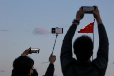 FILE PHOTO: People take pictures of the lowering ceremony of