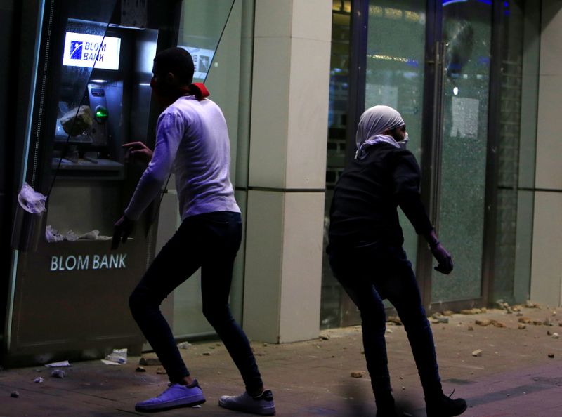 A protestor throws an object at an ATM machine of