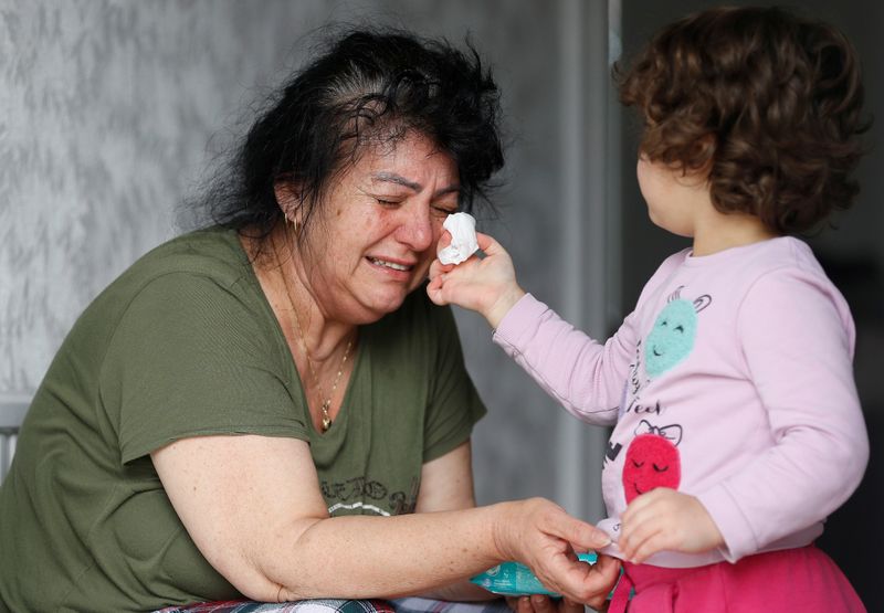 Ayse Mehmet has tears wiped by her three-year-old granddaughter, also