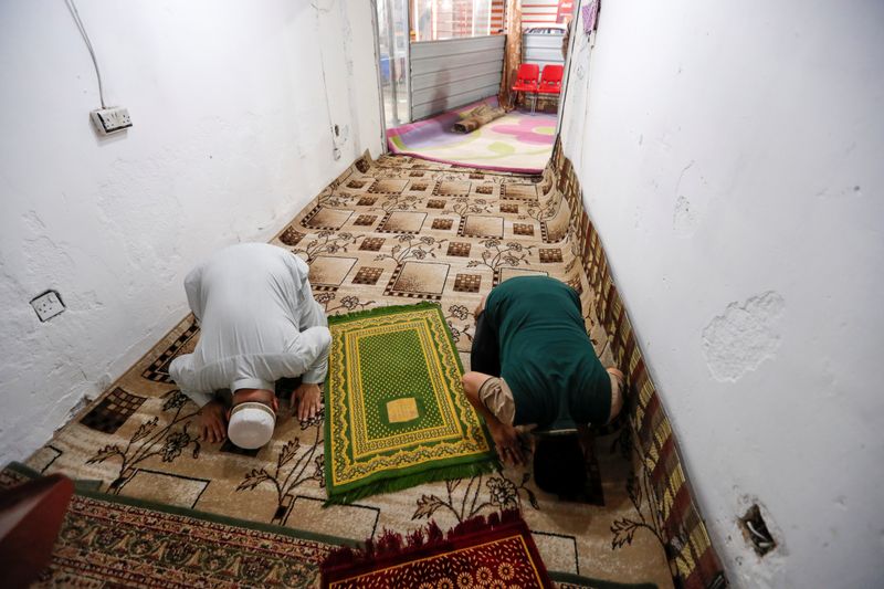 Iraqi muslims perform Ramadan prayers at a store, after the
