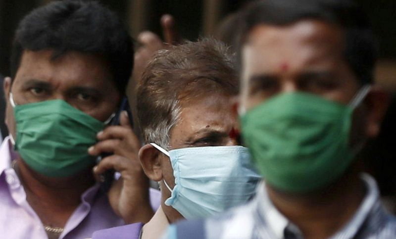FILE PHOTO: Men wearing protective masks walk inside the premises