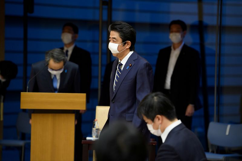 FILE PHOTO: Japan’s Prime Minister Shinzo Abe walks wearing a