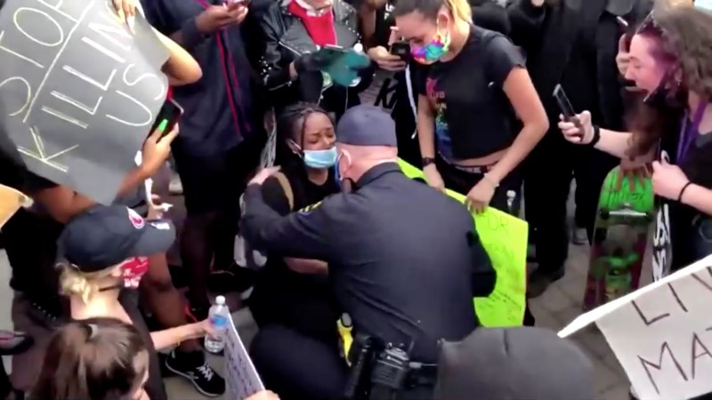 Police officer Eric Christiansen hugs a protester in Oakley, California