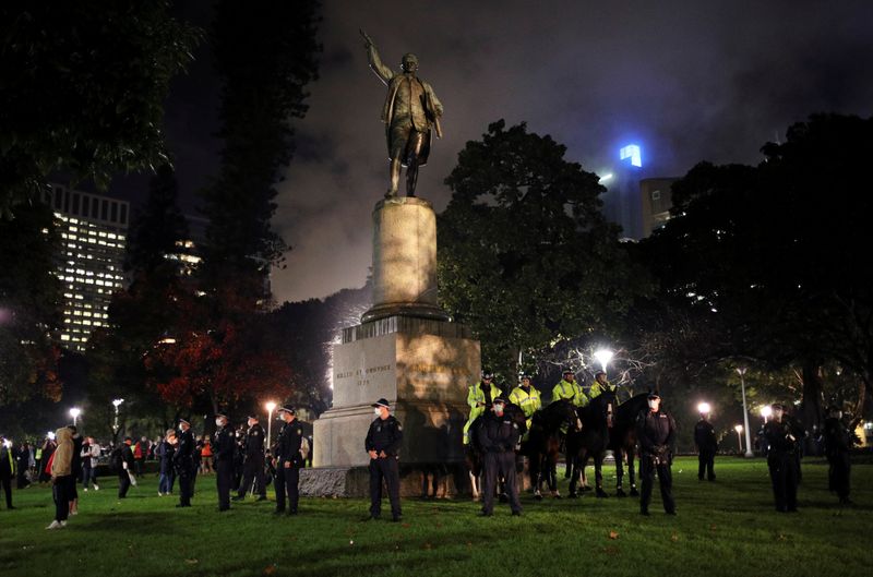 Police officers stand guard around the statue of British explorer