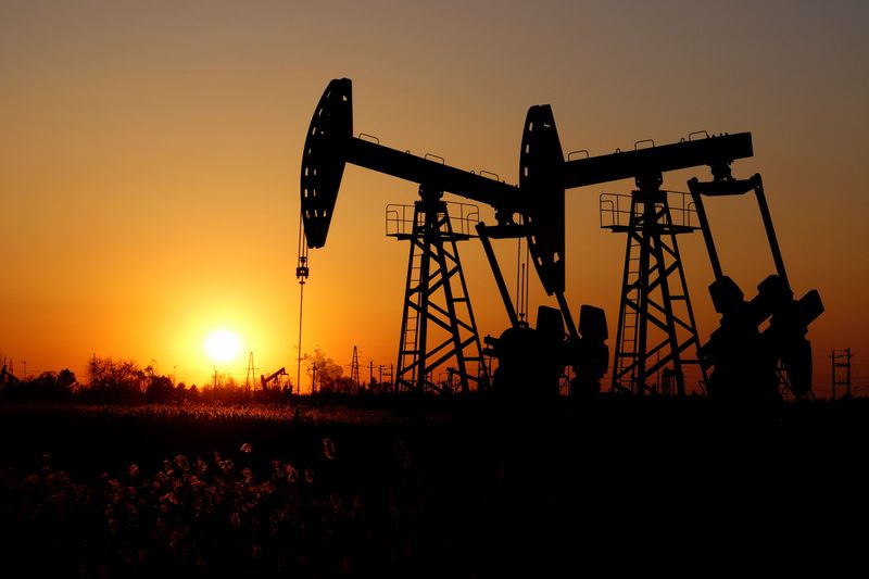 Pumpjacks are seen against the setting sun at the Daqing