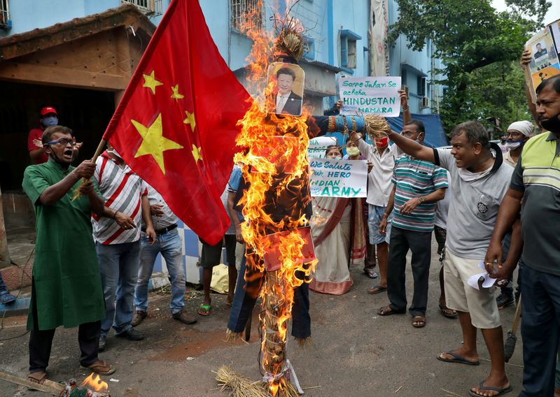FILE PHOTO: Demonstrators shout slogans as they burn an effigy