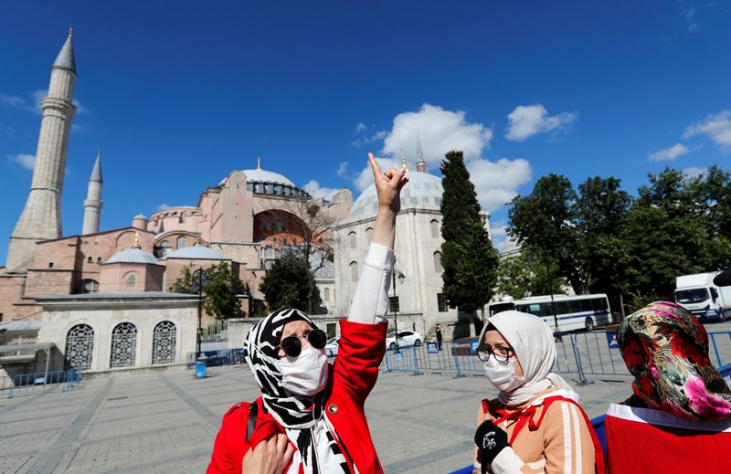 A woman gestures in front of the Hagia Sophia or