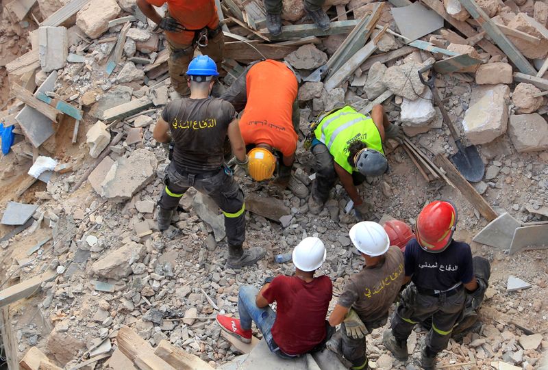 Rescue team members search through rubble of buildings damaged due