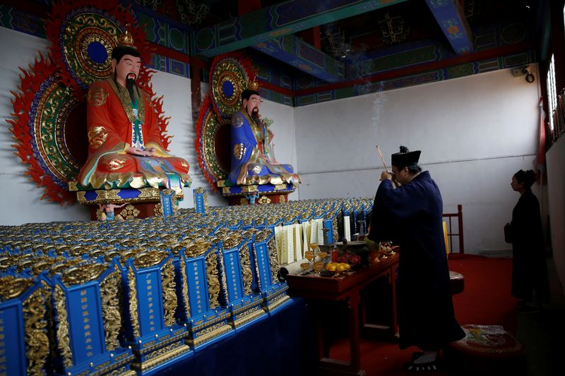 The Wider Image: Taoist priest honours China’s coronavirus dead with