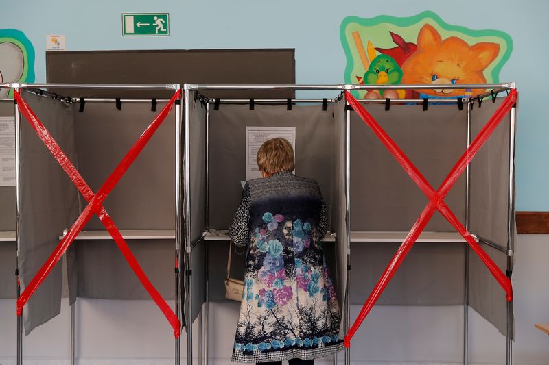 Woman checks her ballot in a voting booth during local