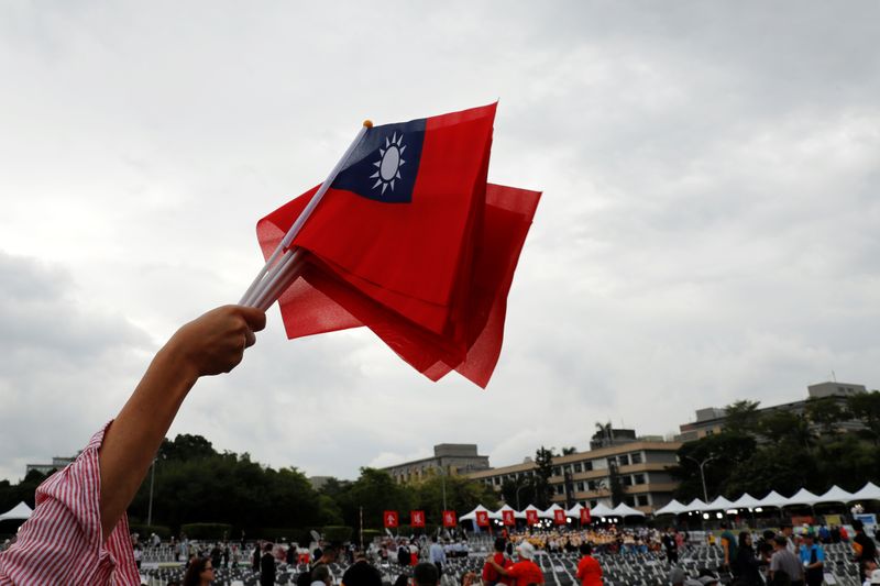 An audience waves Taiwanese flags during the National Day celebrations
