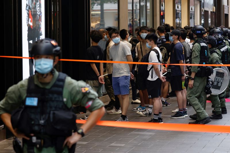 Riot police officers detain people during a protest in Hong