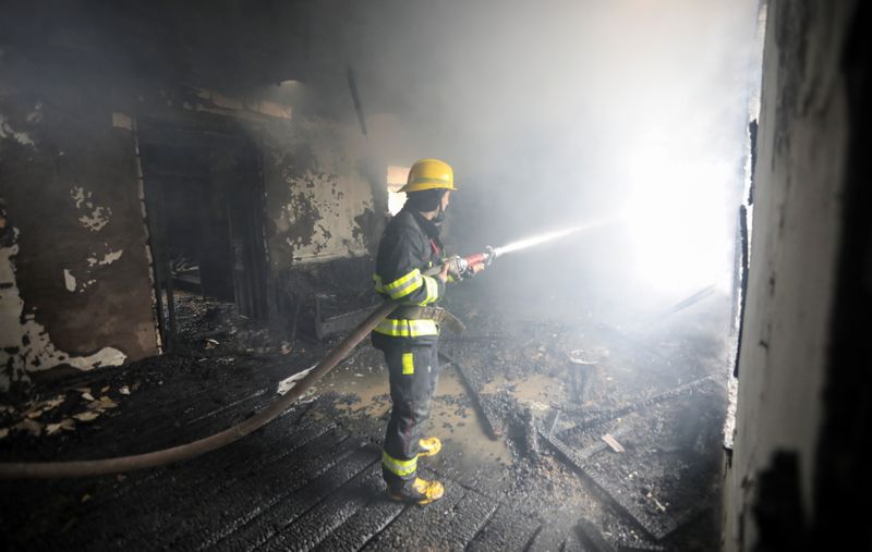 A firefighters extinguishes a fire in a house caused by