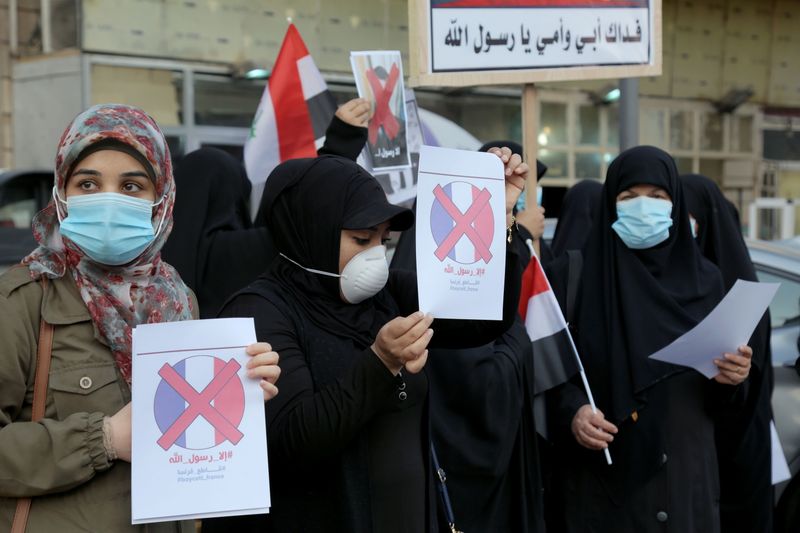 Iraqi people gather during a protest against the publications of