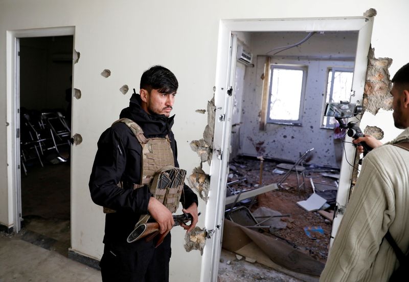 An Afghan policeman inspects the site after yesterday’s attack at