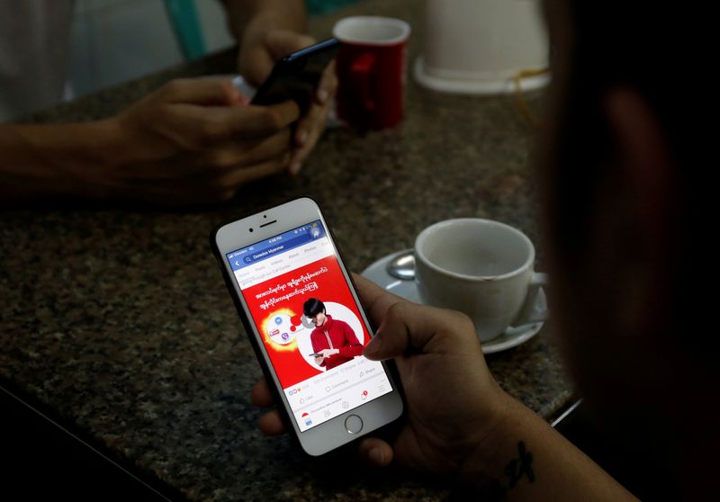 FILE PHOTO: A cellphone user looks at a Facebook page