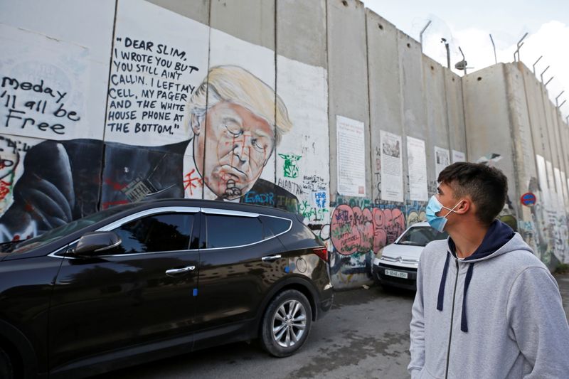 A Palestinian man walks past an anti-U.S. President Donald Trump
