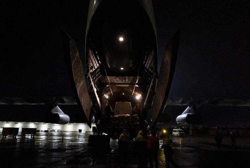 Workers unload a shipment of humanitarian aid from a plane