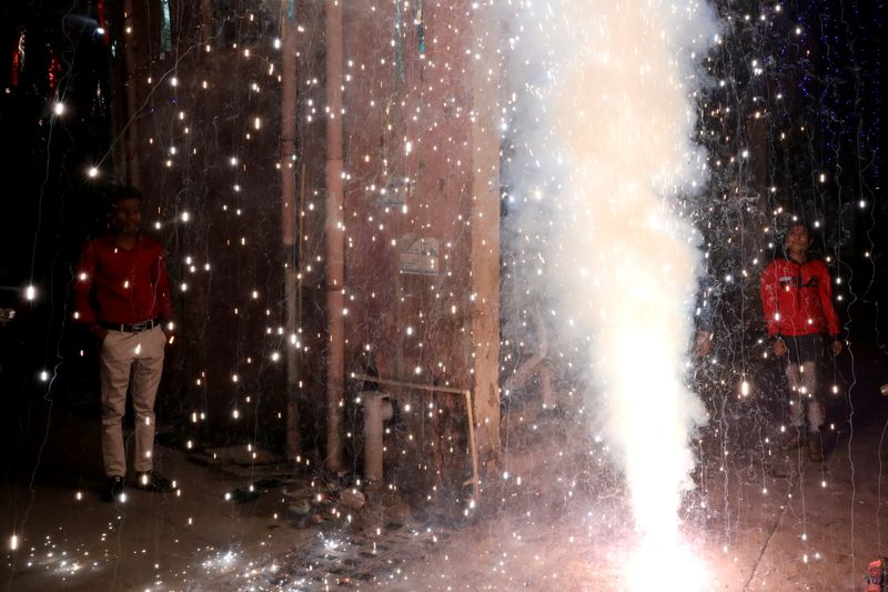 People watch as firecrackers burn during Diwali, the Hindu festival