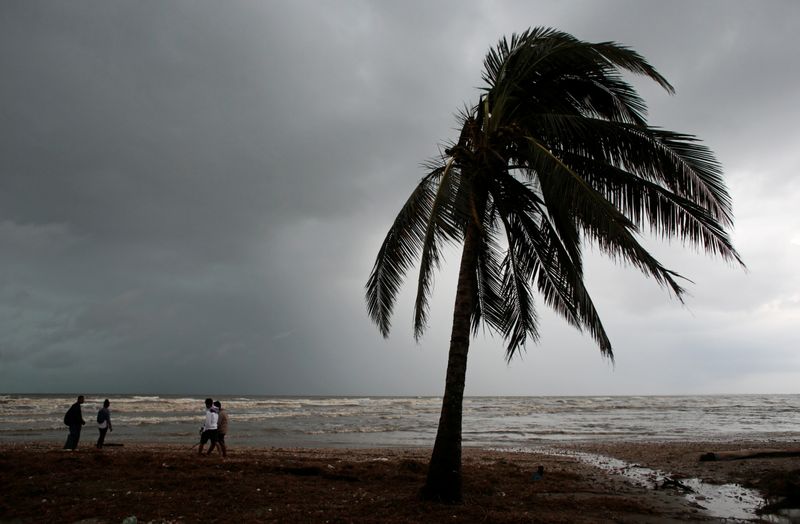 Residents walk along a beach after the passing of Hurricane