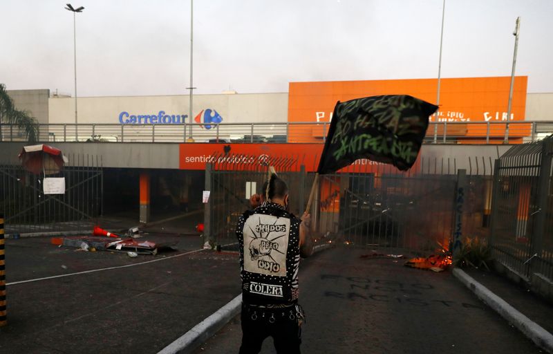Demonstrators vandalize a Carrefour store during a protest against racism,