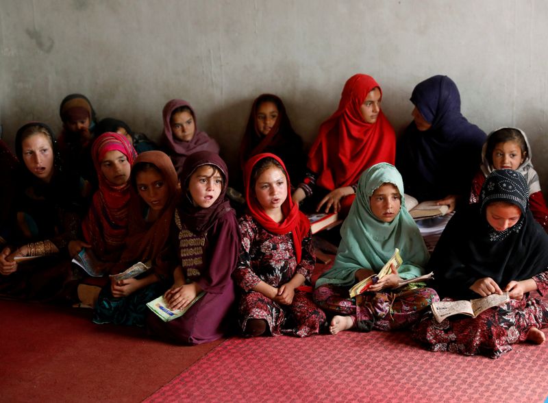 Internally displaced Afghan girls read the Koran at a mosque,