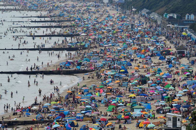 FILE PHOTO: People enjoy Bournemouth Beach during an unusual heat