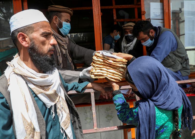 An Afghan girl receives free bread distributed by the government,