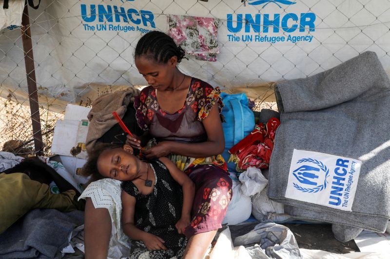 A woman braids a girl’s hair in the Hamdeyat refugee