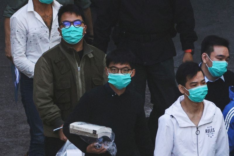 Pro-democracy activists Ivan Lam and Joshua Wong walk to prison