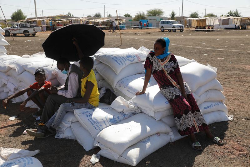 FILE PHOTO:  Ethiopian refugees sit on bags of food