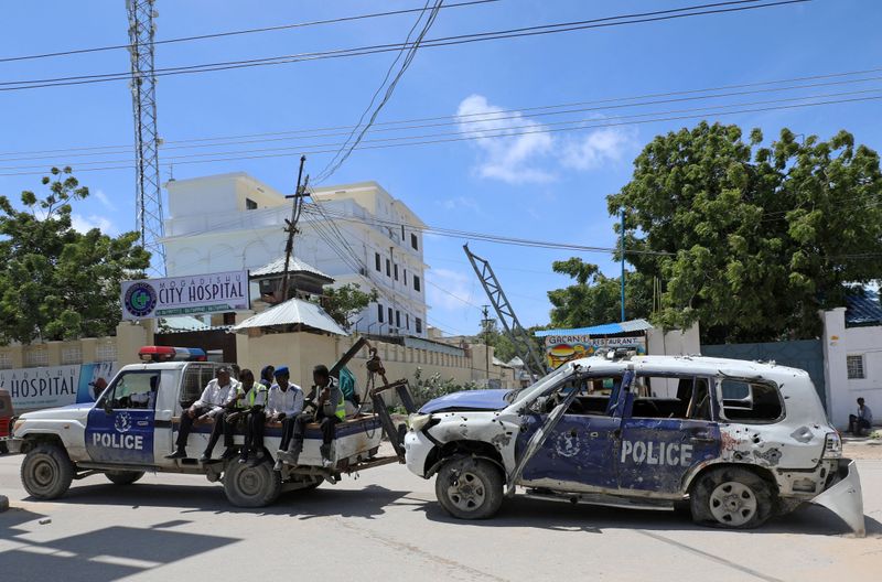 FILE PHOTO: Somali police officers tow their car from the