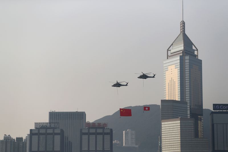 FILE PHOTO: Helicopters carrying China’s national flag and Hong Kong’s