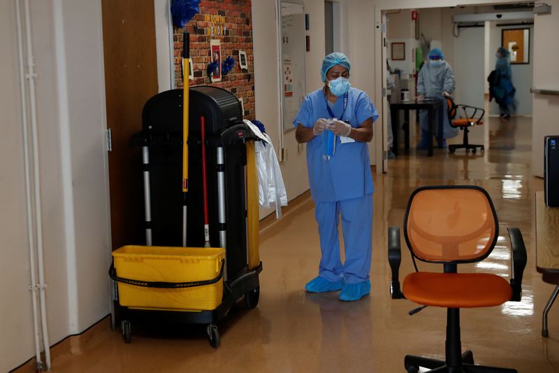 A hospital housekeeper at Roseland Community Hospital looks down before