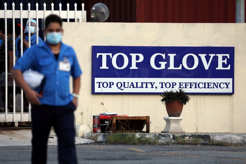 A worker leaves a Top Glove factory after his shift