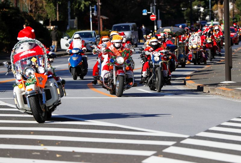 People dressed in Santa Claus costumes ride their motorbikes during