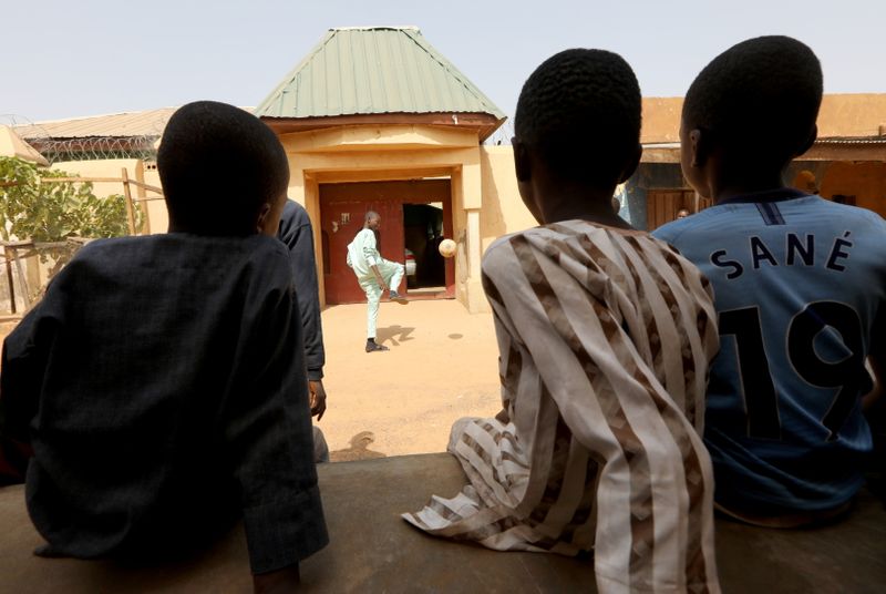 A freed Nigerian schoolboy plays football as he returns home,
