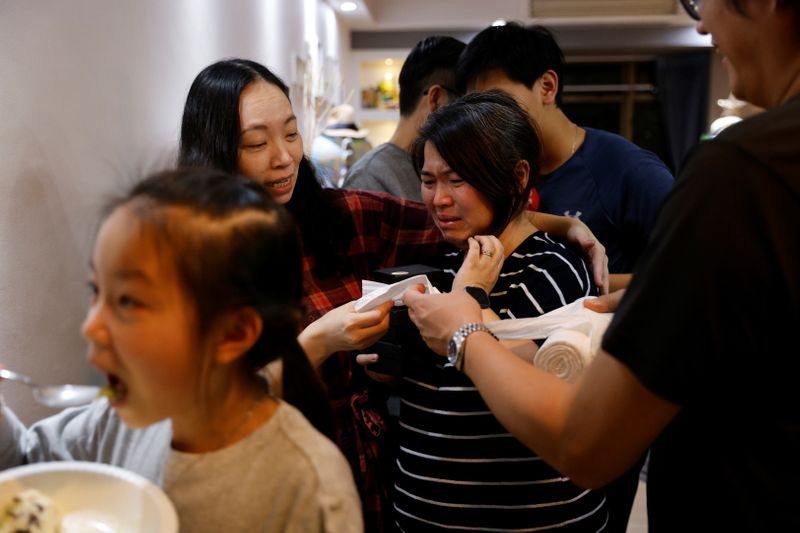 The Wider Image: Leaving Hong Kong: A family makes a